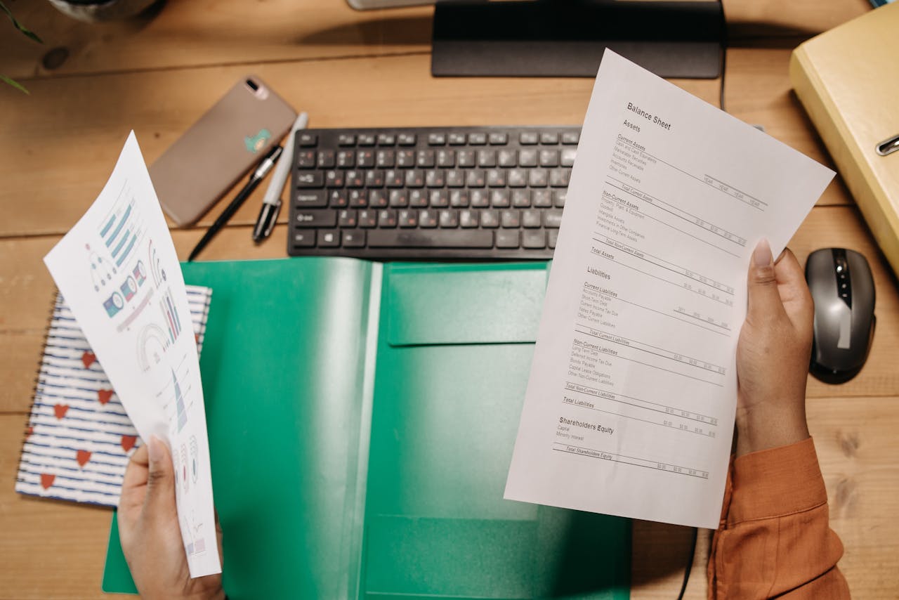core-values Hands holding and reviewing balance sheets over a desk with a keyboard and stationery.